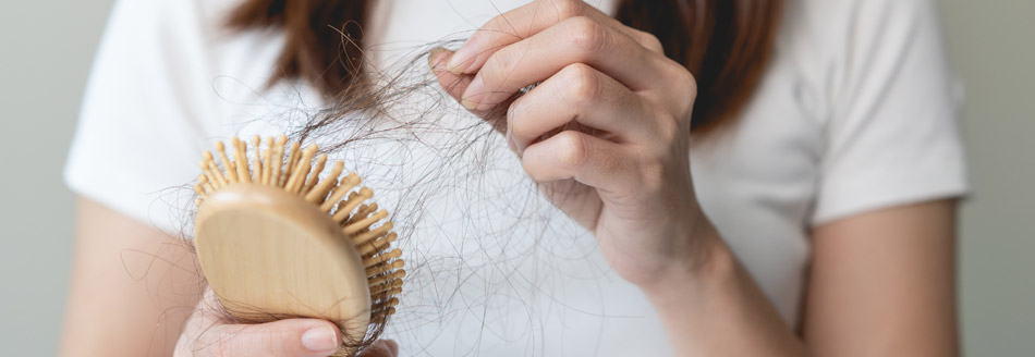 Haarbürste voller Haare. Eine Folge von Eisenmangel kann Haarausfall sein.