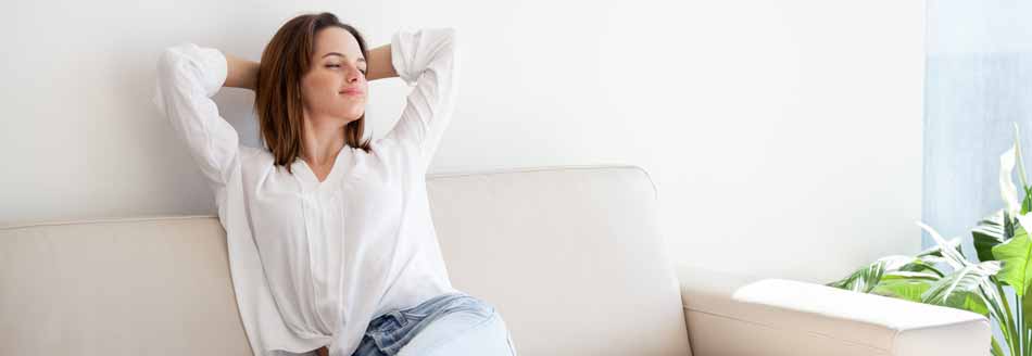 5 Tipps gegen Rauchgeruch: Eine Frau sitzt auf der Couch