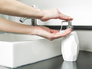 Hände waschen: Eine Frau gibt Seife auf ihre Hände