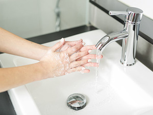 Hände waschen: Eine Frau wäscht sich die Hände mit warmen Wasser