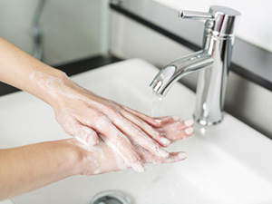 Hände waschen: Eine Frau reibt sich die Hände mit Seife ein