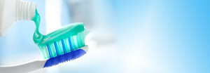 Bunte Zahnpasta wird auf eine Zahnbürste gedrückt
