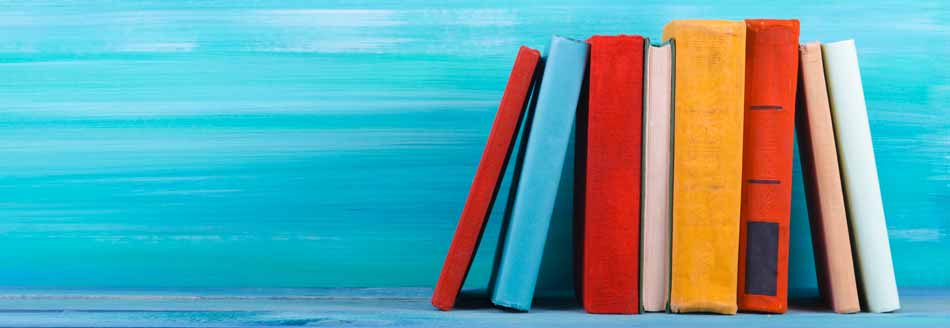 Eselsohren: Einige Bücher stehen vor einer blauen Wand