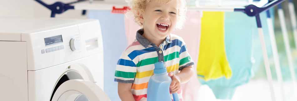 Weichspüler: Ein lachendes Kind hält eine Flasche Weichspüler