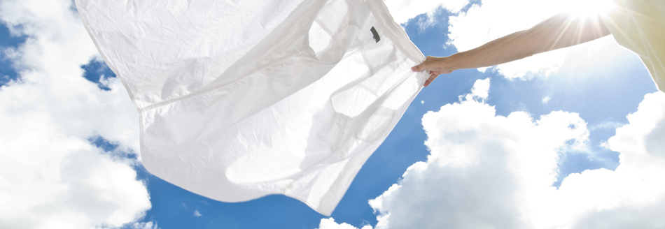 Feinwaschmittel: Eine Bluse flattert vor blauem Himmel im Wind