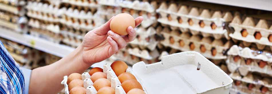 Aufdruck auf dem Ei: Eine Frau kauft Eier im Supermarkt