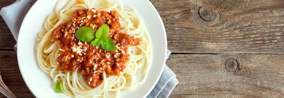 Blitzrezept: Spaghetti Bolognese steht auf einer Holzfläche