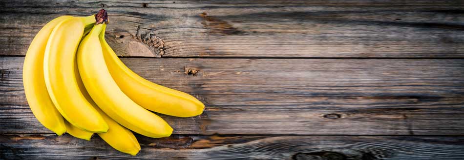 Einige Bananen liegen auf Holz