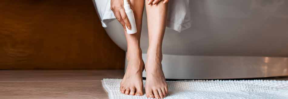 Geschwollene Beine: Eine Frau hält sich den Knöchel