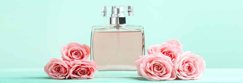 Parfumfehler: Ein Flacon steht neben Rosenblüten