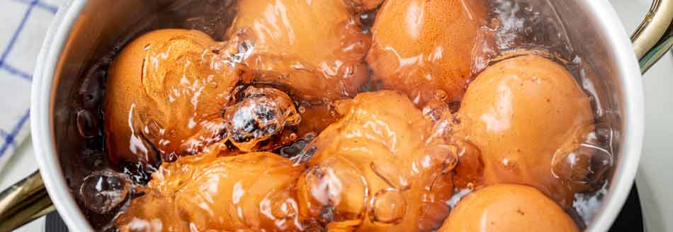 Eier kochen mit Essig: Ein Topf mit Eiern in kochendem Wasser