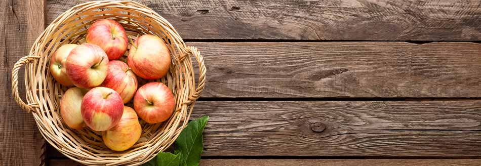 Äpfel lagern: Ein Korb mit Äpfeln steht auf Holz