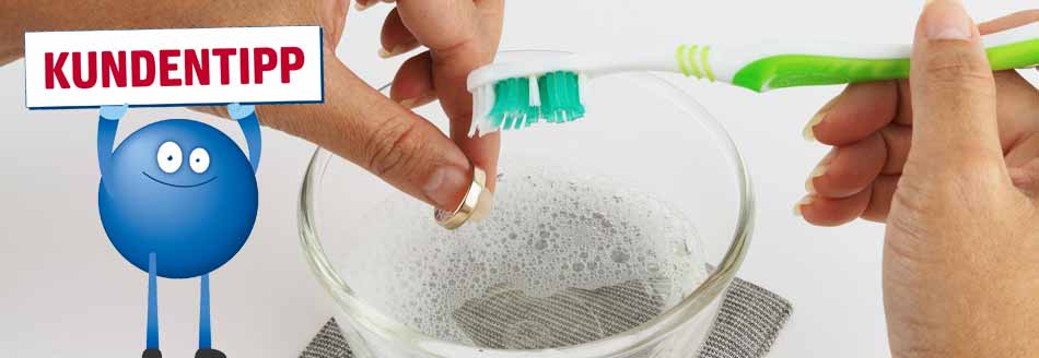 Schmuck reinigen mit Backpulver: Eine Frau putzt Schmuck mit einer Zahnbürste