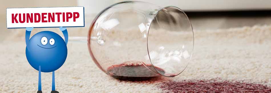 Rotweinflecken mit Weißwein entfernen: Ein umgefallenes Glas mit Rotwein auf einem Teppich