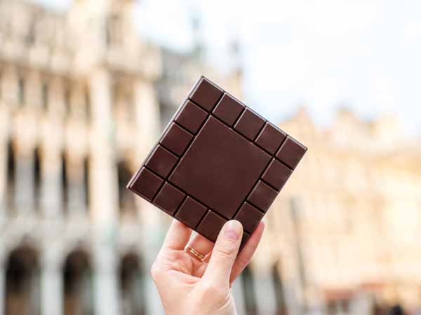 Abnehmen ohne Hunger: Eine Frau hält Schokolade in die Höhe