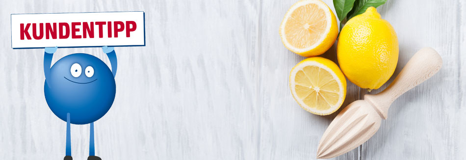 Zitrone hilft gegen Kalk: Drei Zitronen liegen neben einer Saftpresse