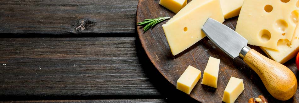 Ist Käse vegetarisch? Aufgeschnittener Käse liegt auf einem Holzbrett