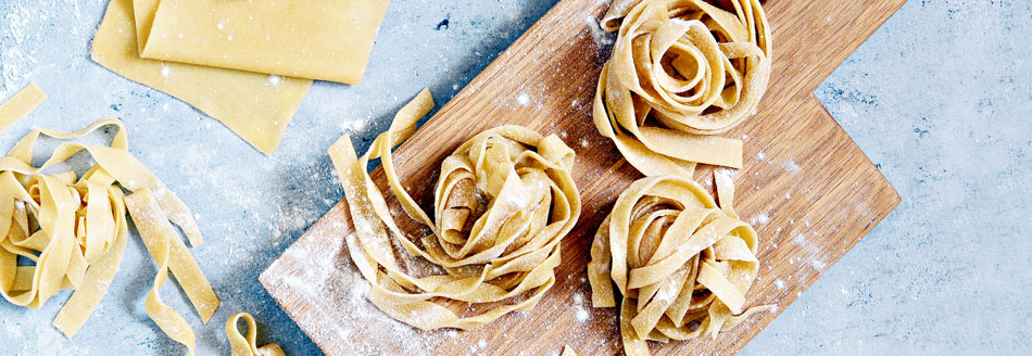 Pasta: Frische Pappardelle liegen auf einem Holzbrett