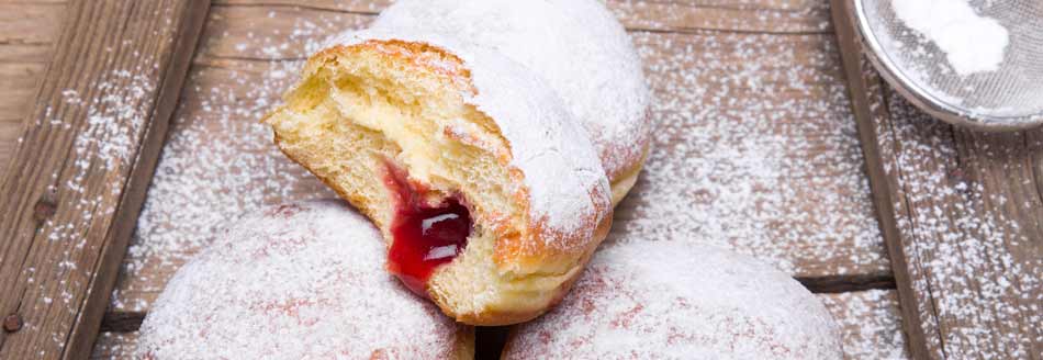 Pfannkuchen bzw. Krapfen auf einem Holzbrett