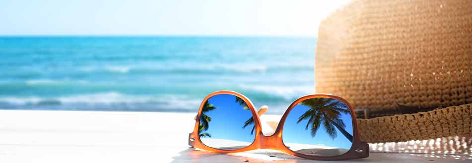 Ferien 2022: Sonnenhut und Sonnenbrille am Strand