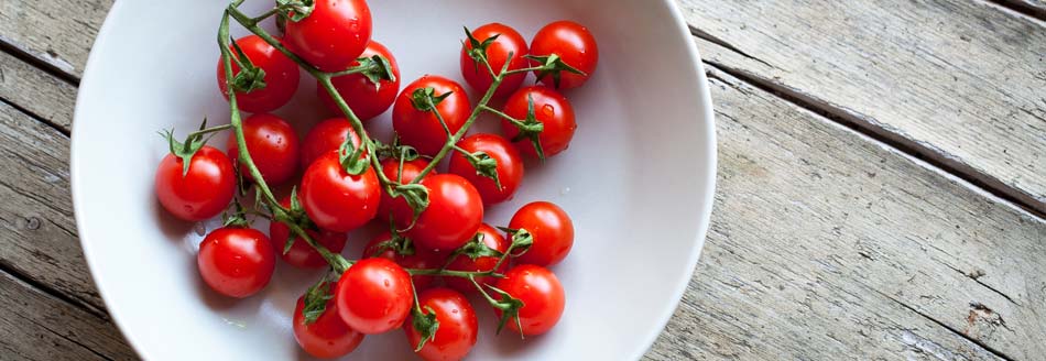 Tomaten mit Stängel auf einem Teller