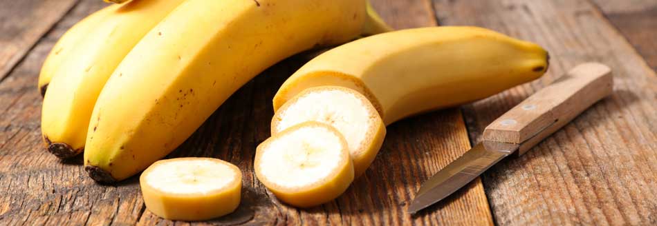 Bananenschale essen: aufgeschnittene Banane auf Holz