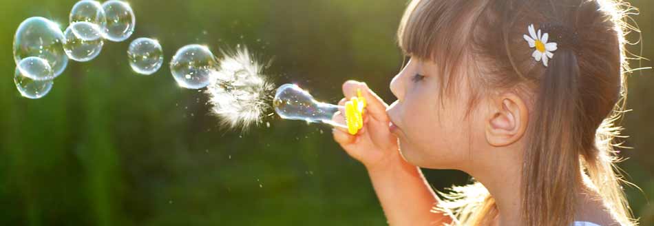 Blasring für Seifenblasen: Ein Mädchen pustet Seifenblasen