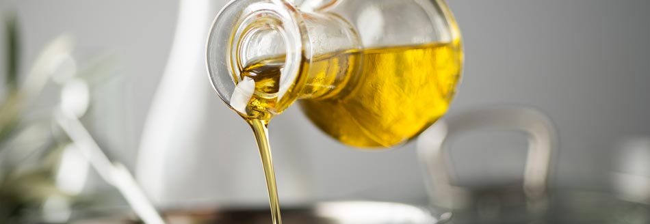 Kalorien Olivenöl: Jemand gießt Olivenöl in eine Pfanne
