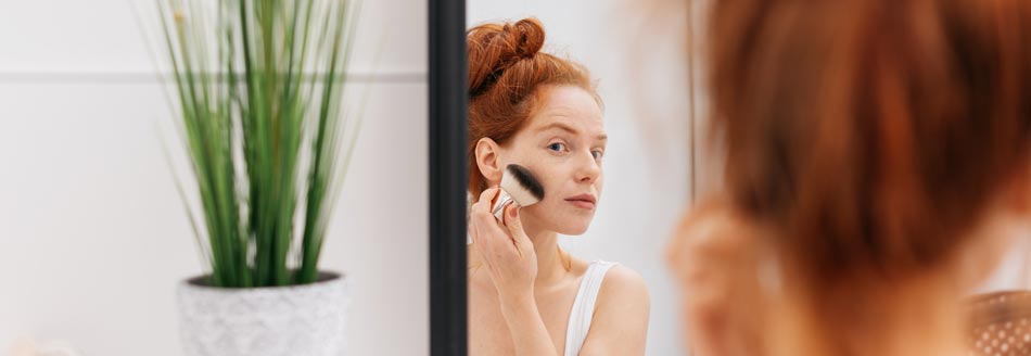 Eine Frau schminkt sich mit einem Make-up-Pinsel