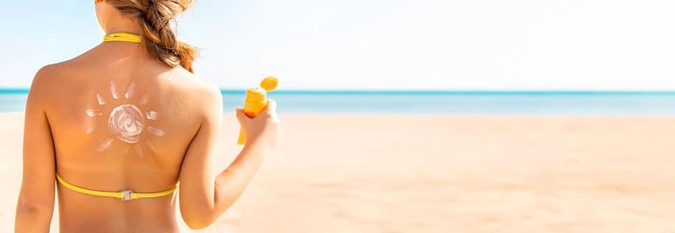 Alte Sonnencreme kann krebserregend sein: eine Frau am Strand