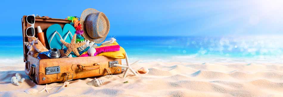 Ferien 2025: ein Koffer liegt am Strand