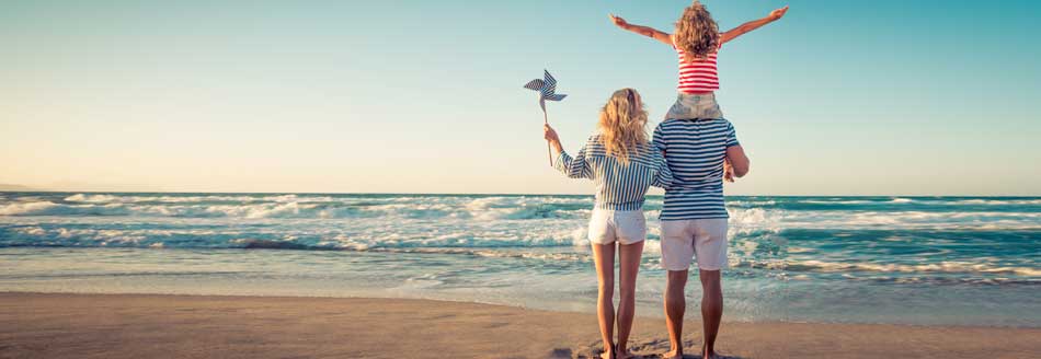 Ferien 2026: Eine Familie freut sich im Urlaub über die Schulferien