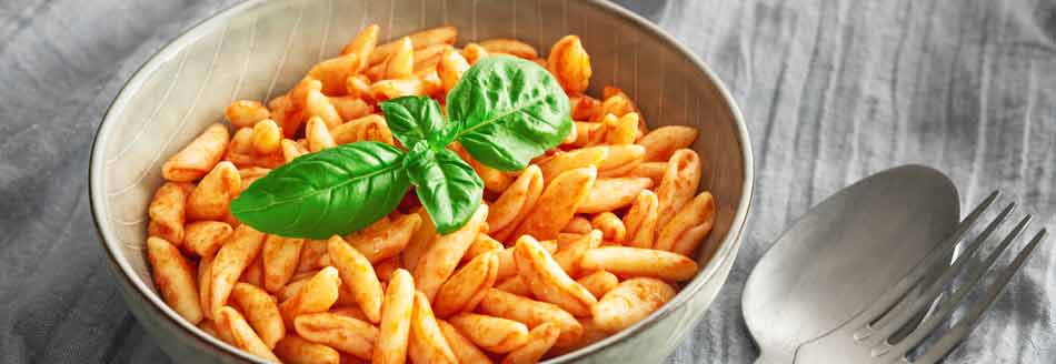 Gekochte Cavatelli mit Tomatensoße und einem schicken Basilikumzweig