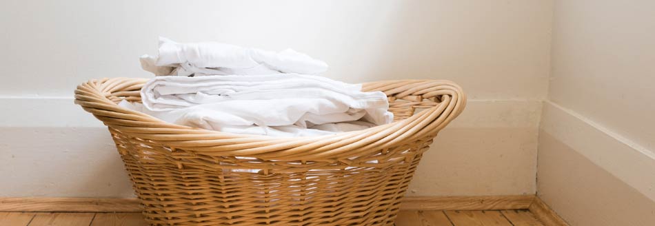 Bettwäsche wartet im Wäschekorb auf ihre Fahrt in der Waschmaschine