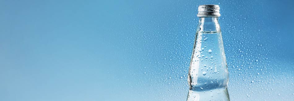 Kondenswasser kullert an einer eiskalten Wasserflasche herunter