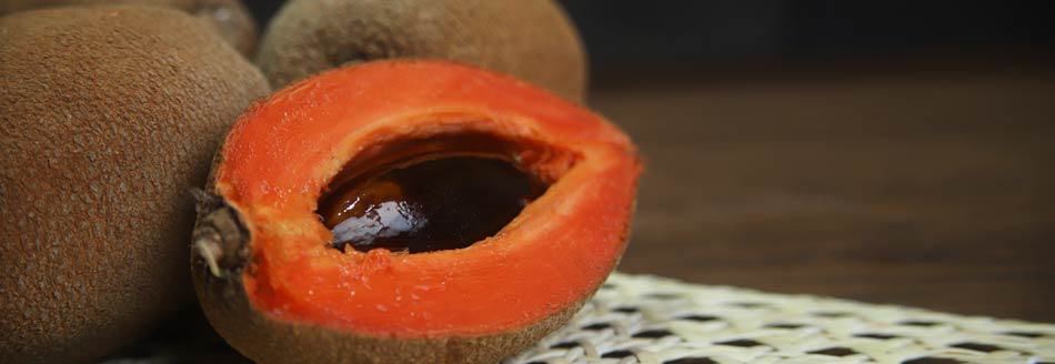 Eine halbe Sapote liegt mit ihren noch ganzen Freunden herum