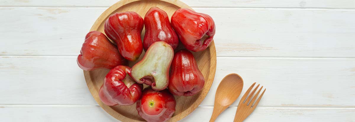 Einige Chompus liegen mit einer aufgeschnittenen Obstkollegin auf einem Holzteller