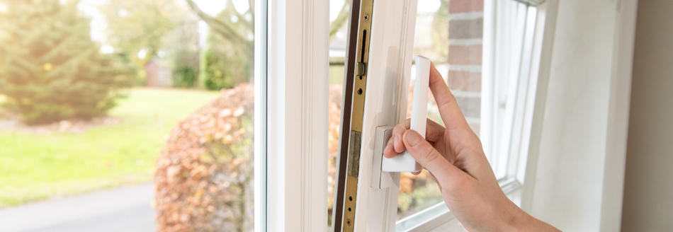 Jemand öffnet ein Fenster und stellt es in Kippstellung.