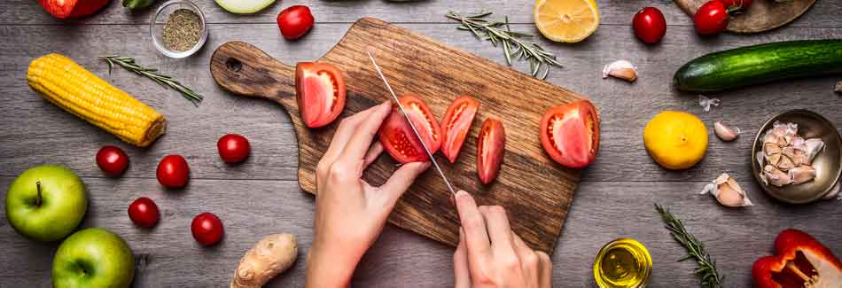 Stoffwechseldiät: Eine Frau schneidet Obst und Gemüse