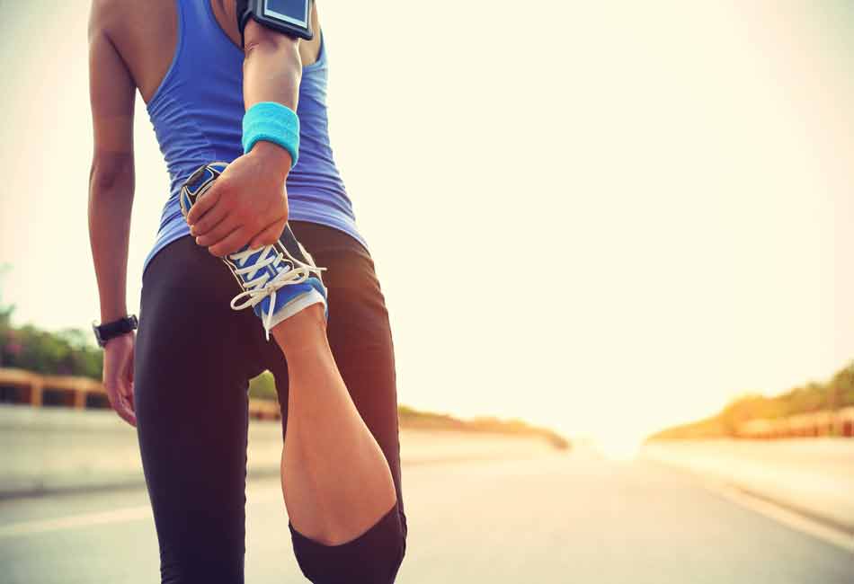 PAYBACK Ratgeber Fitness: Eine junge Frau dehnt die Oberschenkelmuskeln