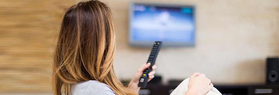Fernseher kaufen: Eine junge Frau sieht fern