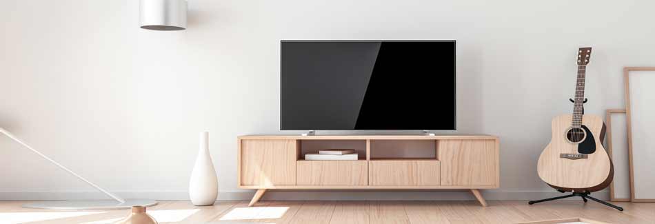Fernseher kaufen: Ein Fernseher steht in einem Wohnzimmer auf einem Sideboard