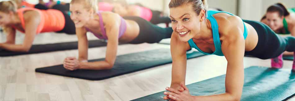 Junge Frauen machen Planking im Fitnessstudio