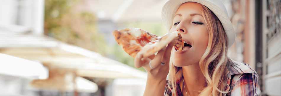 Abnehmen ohne Hunger: Eine Frau pfeift auf Diät und isst Pizza