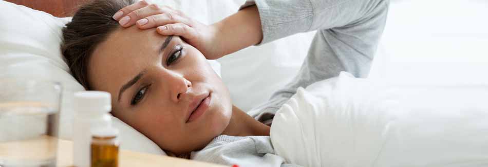 Erkältung vorbeugen: Eine Frau liegt mit Erkältung im Bett