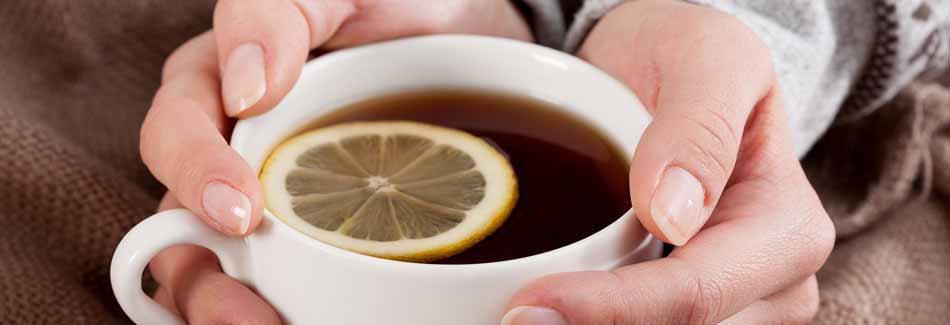 Erkältung vorbeugen: Eine Frau hält eine Tasse Tee in den Händen